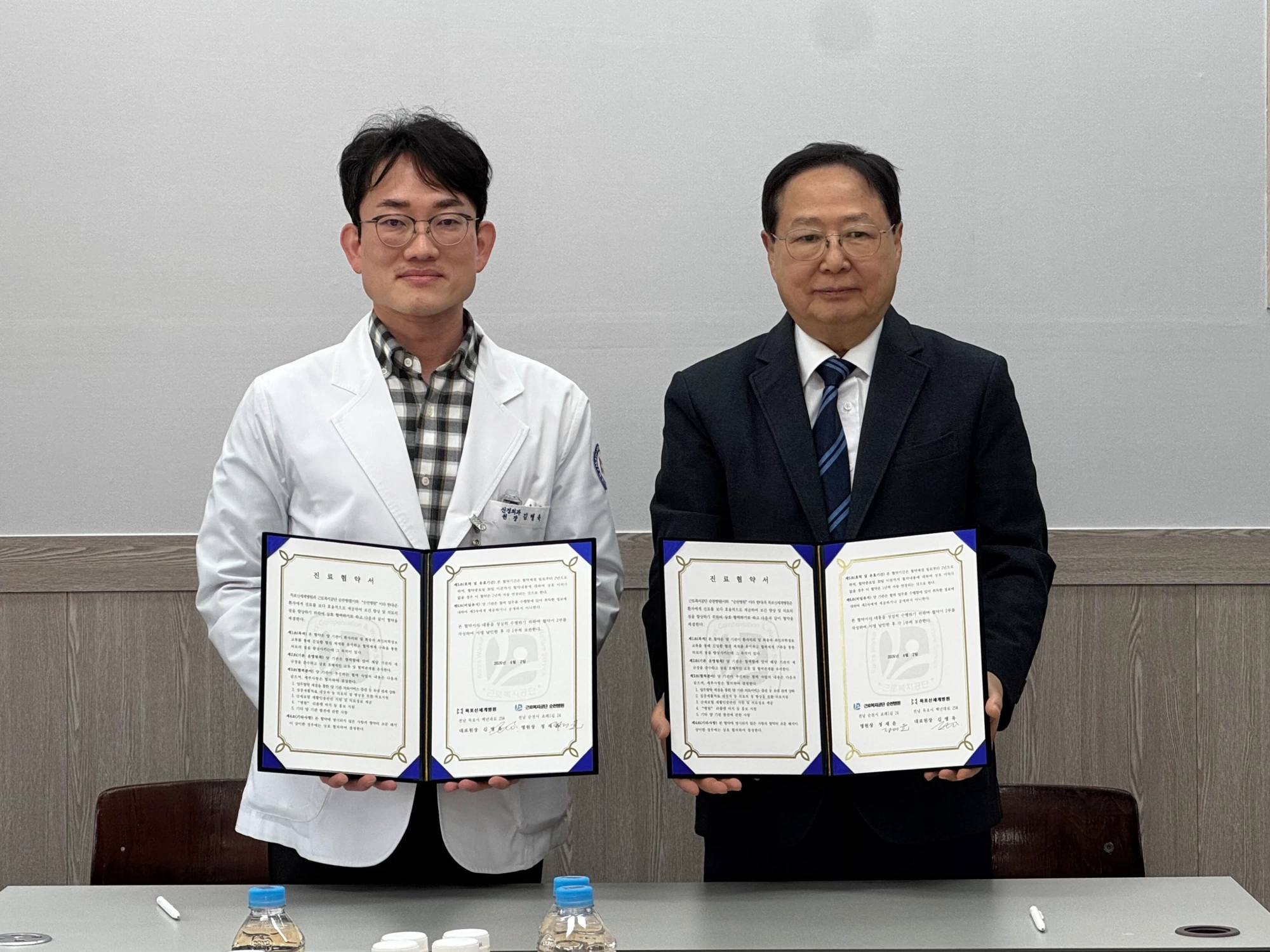 목포신세계병원 김병욱 대표원장과 근로복지공단 순천병원 정재윤 병원장이 서명된 진료협약서를 들고 서 있다.